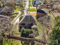 An aerial view displays the backyard of a brick home, including the fence line and surrounding neighborhood at 11402 Bloomfield Dr, Charlotte, NC 28277