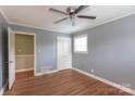 Inviting bedroom featuring hardwood floors, a ceiling fan, and ample natural light from a window at 128 Summerlea Dr, Charlotte, NC 28214