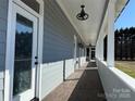 Inviting covered front porch with wood-look tile flooring and stylish ceiling fans offers outdoor relaxation at 135 Waycross Dr, Rockwell, NC 28138