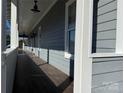 Covered front porch with wood-look tile flooring and natural light perfect for outdoor entertaining at 135 Waycross Dr, Rockwell, NC 28138