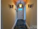 Hallway featuring tiled floor, wooden ceiling and a white front door at 135 Waycross Dr, Rockwell, NC 28138