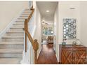 Bright foyer with hardwood floors, staircase, and a view of the living room, creating a welcoming entrance at 14104 Green Birch Dr, Pineville, NC 28134
