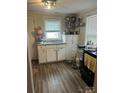 Cozy kitchen featuring wood-look floors and white cabinets at 3931 Bearwood Ave, Charlotte, NC 28205