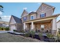 Beautiful two-story home featuring stone and siding details, a covered porch, and manicured landscaping at 4027 Wiltshire Ln, Indian Land, SC 29707