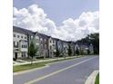 A charming street view of a neighborhood filled with colorful townhomes and tree-lined sidewalks at 434 Serenity Cir # F, Cramerton, NC 28032