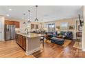 Bright open-concept layout featuring a kitchen island with granite countertops, stainless steel appliances, and a living area at 473 Bowline Dr, Denver, NC 28037