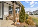 Cozy porch with wooden pillars, wicker chairs, greenery, and the house number displayed on a stone at 473 Bowline Dr, Denver, NC 28037