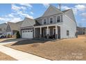 Charming two-story home featuring stone accents, covered porch, attached garage and well-manicured lawn at 7019 Lenton Rd, Charlotte, NC 28215
