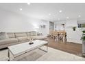 Open-concept living room with a large sectional, hardwood floors, and seamless flow into the dining area at 7314 Entwhistle Ct, Charlotte, NC 28226