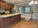 Open kitchen boasts granite countertops, stainless steel appliances, and hardwood floors at 11724 Blessington Rd, Huntersville, NC 28978