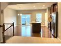 Open floor plan with kitchen island, stainless appliances, and a door to the deck at 11724 Blessington Rd, Huntersville, NC 28978