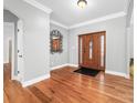 Foyer with hardwood floors, paneled wood front door, and decorative mirror at 148 Castle Dr, Mooresville, NC 28117