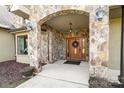 Covered front entrance featuring stone archway, wood door with wreath, and pendant lighting at 148 Castle Dr, Mooresville, NC 28117