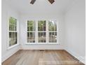 Bright room featuring hardwood floors, white walls, and a view of the wooded lot behind the home at 19155 Newburg Hill Rd, Davidson, NC 28036