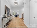 Bright foyer with wood floors, stylish console table, and an open view to the living area at 19155 Newburg Hill Rd, Davidson, NC 28036