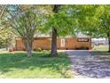 Brick ranch-style home with mature trees and a well-kept lawn offering a serene setting and classic charm at 2004 Grandhaven Dr, Concord, NC 28027