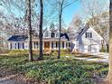 Charming two-story home featuring mature trees, a manicured lawn, and an attached two-car garage at 2050 Tite Rd, Stanfield, NC 28163
