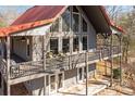 Charming home with a red roof, gray siding, a spacious deck, and ample natural light from large windows at 221 Island Terrace Rd, Statesville, NC 28677