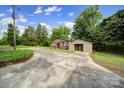 Home with detached garage and a concrete driveway amidst a yard with shrubbery and lush greenery at 2988 Great Falls Hwy, Lancaster, SC 29720