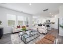 Bright living room with stylish decor, including modern furniture, large windows, and an open layout with a view of the kitchen at 321 Brinkley Dr, Kings Mountain, NC 28086