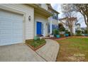 Inviting entrance featuring a blue door, well-maintained landscaping, and a sidewalk to the front door at 5707 Brandy Ridge Ln, Charlotte, NC 28269