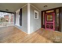 Inviting porch view showcasing wooden floors, a pink-trimmed front door, and black shutters at 613 S Mulberry St, Statesville, NC 28677