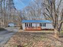Charming home featuring a blue roof, new deck, and manicured landscaping at 1075 Fye Dr, Newton, NC 28658