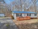 Charming home featuring a blue roof, new deck, and manicured landscaping at 1075 Fye Dr, Newton, NC 28658