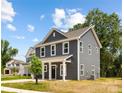 Gray two-story home with white trim and a cozy front porch, nestled in a growing neighborhood at 1124 Thayer Glen Ct, Charlotte, NC 28213