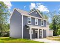 Side view of a gray two-story home with white trim, a cozy front porch, and well-manicured lawn at 1124 Thayer Glen Ct, Charlotte, NC 28213