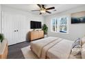 Virtually staged bedroom with modern dresser and ceiling fan at 11430 Gelding Dr, Charlotte, NC 28215