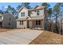 Charming two-story home with neutral siding and concrete driveway situated among mature trees at 2204 Hillcrest Ave, Albemarle, NC 28001