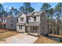Two-story home boasts neutral siding, a new roof, and a concrete driveway surrounded by trees at 2204 Hillcrest Ave, Albemarle, NC 28001
