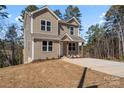 Two-story home with neutral siding, and a concrete driveway surrounded by mature trees at 2204 Hillcrest Ave, Albemarle, NC 28001