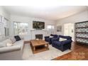 Inviting living room showcasing a charming fireplace, large windows, and beautiful hardwood floors at 2304 Dilworth W Rd, Charlotte, NC 28203