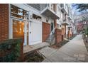 Townhouse exterior featuring a brick and gray wood facade, small balconies, and front door at 287 Mcdonald Ave, Charlotte, NC 28203