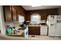 Traditional kitchen with wood cabinets, white appliances, and a window above the sink at 3331 Tamworth Ln, Gastonia, NC 28052