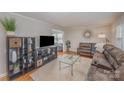 Cozy living area features a large brown sofa, hardwood floors, and stylish shelving for storage at 4001 Glenfall Ave, Charlotte, NC 28210