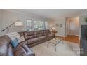 Inviting living room with a large, comfortable brown leather sofa and plenty of natural light at 4001 Glenfall Ave, Charlotte, NC 28210