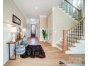 Inviting foyer with hardwood floors, a staircase with iron railings, and elegant decor at 4114 Thames River Pl, Harrisburg, NC 28075