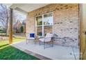 Inviting front porch featuring comfortable seating, a brick wall, and a view of the neighborhood at 4114 Thames River Pl, Harrisburg, NC 28075