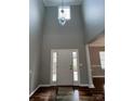 Bright foyer with a high ceiling, decorative chandelier, and a front door flanked by sidelight windows at 5934 Hickory Hollow Ct, Harrisburg, NC 28075