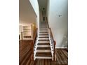Elegant staircase with wood treads, white risers, and ornate black iron spindles at 5934 Hickory Hollow Ct, Harrisburg, NC 28075