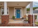 Welcoming front porch with a bright blue door and cozy decor at 7602 Rolling Meadows Ln, Huntersville, NC 28078