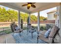 Relaxing screened porch featuring comfortable seating, a ceiling fan, and serene backyard views at 1148 Mckee Farm Ln, Belmont, NC 28012