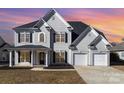 Traditional two-story home with a three-car garage, black shutters and inviting front porch at 132 Elizabeth Hearth Rd, Mooresville, NC 28115
