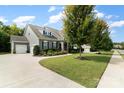 Gray house with stone accents, two-car garage, and a manicured lawn at 1320 Torrens Dr, Wesley Chapel, NC 28110