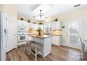 Bright kitchen with island, granite countertops, white cabinets, and wood-look flooring at 8851 Glenside St, Huntersville, NC 28078