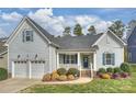 Charming home featuring a covered front porch, two-car garage, manicured lawn and mature landscaping at 11419 Rising Star Ct, Charlotte, NC 28215