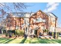 Back exterior of brick home with a wooden deck, lush greenery, and outdoor seating arrangement at 16025 Agincourt Dr, Huntersville, NC 28078